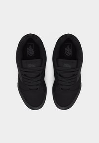 Ζευγάρι μαύρα αθλητικά παπούτσια Vans με κορδόνια, αριστερά από πάνω σε λευκό φόντο.