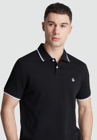 Zwart polo shirt van katoen, met een knoopsluiting van twee knopen, contrasterende kraag en manchetten met witte en blauwe strepen, en een subtiele logo op de borst.
