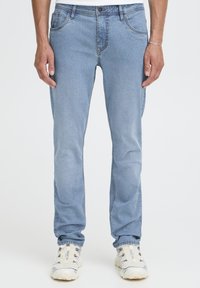 Svetlo modre kavbojke iz jeansa z ravnim krojem, ki imajo pet žepov, zapenjanje na gumb in subtilno bledenje za dodatno teksturo.