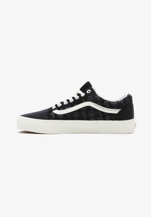 Baskets en toile noire avec un motif de mains monochromes, semelle en caoutchouc blanche et lacets blancs. Design classique Vans avec bande latérale.