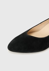Svarte semskede ballettslepper med spiss tå og lav vamp. Har en glatt innerfôr og minimal søm langs kanten.