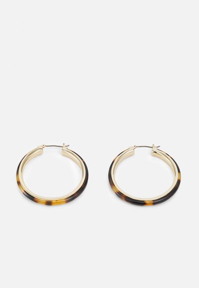 Boucles d'oreilles en métal doré avec un bord extérieur en résine à motif écaille de tortue, dotées d'une finition lisse et d'une forme circulaire élégante.