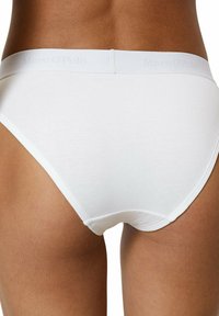 Witte katoenen slips met een zachte tailleband met reliëfbranding. Gladde textuur, aansluitend ontwerp en minimale naden voor comfort.