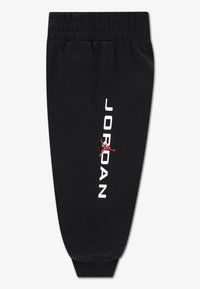 Mustad dressipüksid elastse vöörihmaga, millel on valge "JORDAN" tekst ja vasakul jalal punane Jumpmani logo. Sile kangapind.