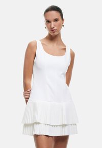 Weißes A-Linien-Kleid mit tailliertem Oberteil und gestuftem, plissiertem Rock. Glattes Material mit klarem Design, das einen weiten, runden Ausschnitt aufweist.