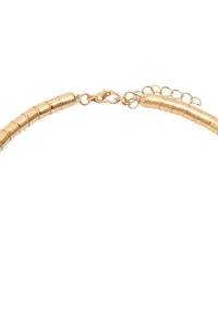 Naszyjnik w złotym odcieniu, ozdobiony cylindrycznymi metalowymi koralikami, z bezpiecznym zapięciem i przedłużką łańcuszka umożliwiającą regulację długości. Gładka i polerowana powierzchnia.