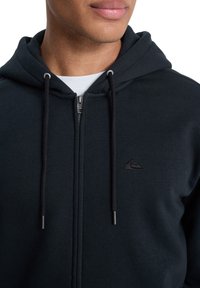 Dunkelblaues Zip-Hoodie aus Baumwollmischung, mit einer Kängurutasche, verstellbaren Kordeln und einem kleinen, strukturierten Logo auf der Brust.