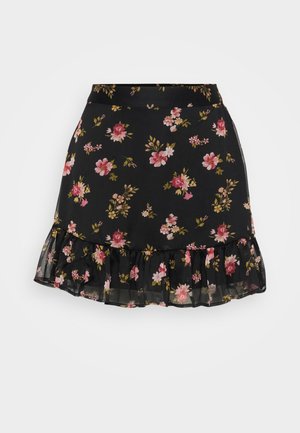 Zwarte bloemenrok met een gerimpelde zoom. Het heeft een patroon van roze en gele bloemen op een doorschijnende stof. Lichtgewicht en aansluitend ontwerp.
