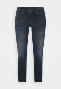 Jeans skinny azul oscuro de mezclilla, con cinco bolsillos, cremallera frontal y cintura con pasadores para cinturón. Zonas descoloridas en los muslos.