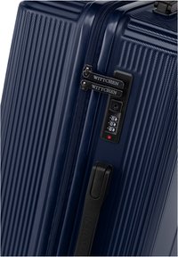 Námořnická modrá tvrdá kufřík s vertikálními drážkami, dvojitými zipy s kombinovaným zámkem a texturovanou rukojetí. Viditelné značení WITTCHEN.