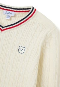 Cremefarbener, gestrickter Pullover mit Zopfmuster, V-Ausschnitt und einem mehrfarbigen gestreiften Kragen. Besitzt ein auf die Vorderseite gesticktes Bären-Icon.