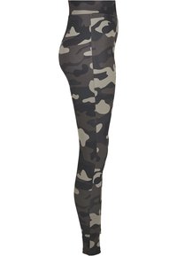 Camouflage leggings featuring a fitted design, made of stretchy fabric in shades of dark green and beige, with a smooth texture.