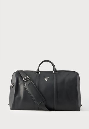 Bolsa de cuero negra tipo duffel con asas, correa de hombro ajustable y un pequeño logo triangular en el centro delantero sobre un fondo blanco.