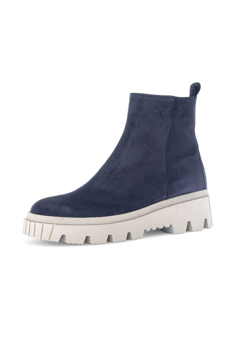 Marineblaue Wildleder-Stiefeletten mit einer klobigen weißen Plattformsohle und geriffelten Rändern. Mit einer Zuglasche an der Rückseite für ein einfaches Anziehen.