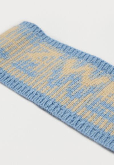 Stickad textilband i ljusblått med kremfärgade geometriska mönster. Har en ribbad textur och mjuk finish. Mäster cirka 4 cm bred.
