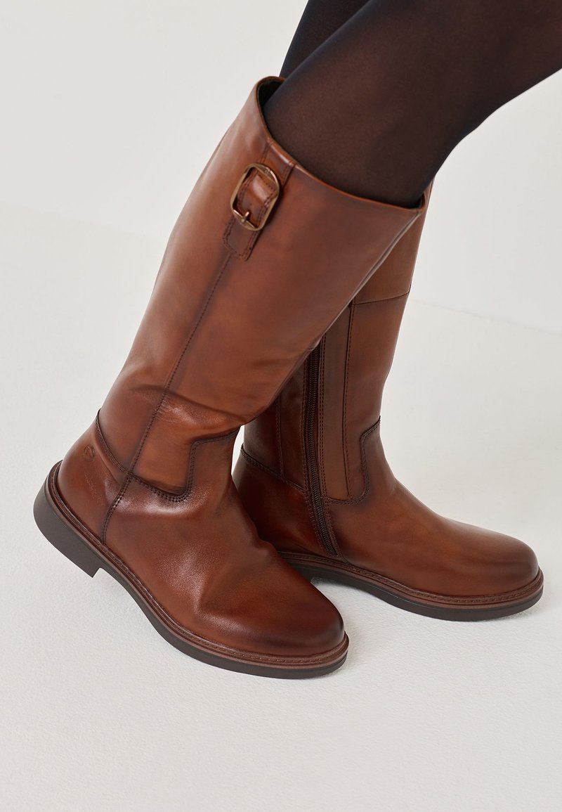 Stivaletti al ginocchio in pelle marrone con cerniera laterale, caratterizzati da una fibbia decorativa e una superficie liscia, su sfondo bianco.