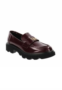 Mocassino in pelle patinata bordeaux con suola nera spessa, caratterizzato da un logo dorato decorativo su una larga fascia che attraversa la tomaia.