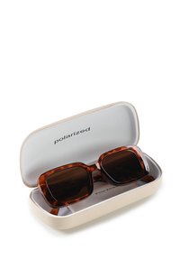 Brązowe okulary przeciwsłoneczne w musztardowej skórzanej etui z napisem "polaryzowane" w środku. Okulary mają prostokątny kształt i ciemne soczewki.