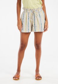 Shorts rayés en tissu léger avec une ceinture froncée, présentant des motifs bleus, jaunes et roses. Portés avec des sandales plates.