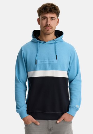 Lys blå og sort hættetrøje med hvid stribe på tværs af brystet, med et logo-patch og snøre detaljer. Blødt stof, afslappet pasform.