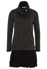 Svart texturerad klänning med en cowl-halsringning och lång ärm, med en spetskjol och en dekorativ brosch vid halslinningen.