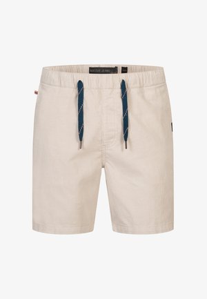 Beżowe szorty z materiału sztruksowego, z elastycznym paskiem w talii i granatowymi sznurkami do ściągania, oraz małą naszywką z logo z boku.