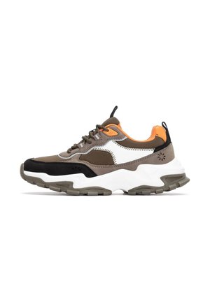 Zapatillas gruesas con un upper en marrón, negro y blanco, acentos naranjas, y una suela blanca gruesa con detalles de goma gris.