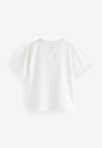 Camiseta de algodón blanca con mangas cortas, escote redondo y costuras en contraste. Parte trasera lisa sin patrones ni diseños visibles.