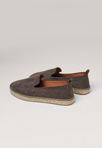 Brune ruskinds slip-on sko med åben top, jute reb sål og syning langs kanten. Glat inderside synlig.