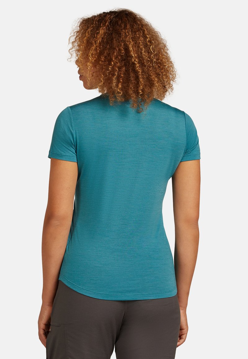 Teal T-shirt met korte mouwen, gemaakt van lichte, gestructureerde stof, met een gebogen onderkant en eenvoudige, strakke lijnen. Zichtbaar stiksel detail.