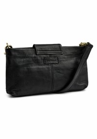 Svart läderhandväska med en slät textur. Har ett vikbart lock, justerbar rem och subtil logotypdetaljering på framsidan.