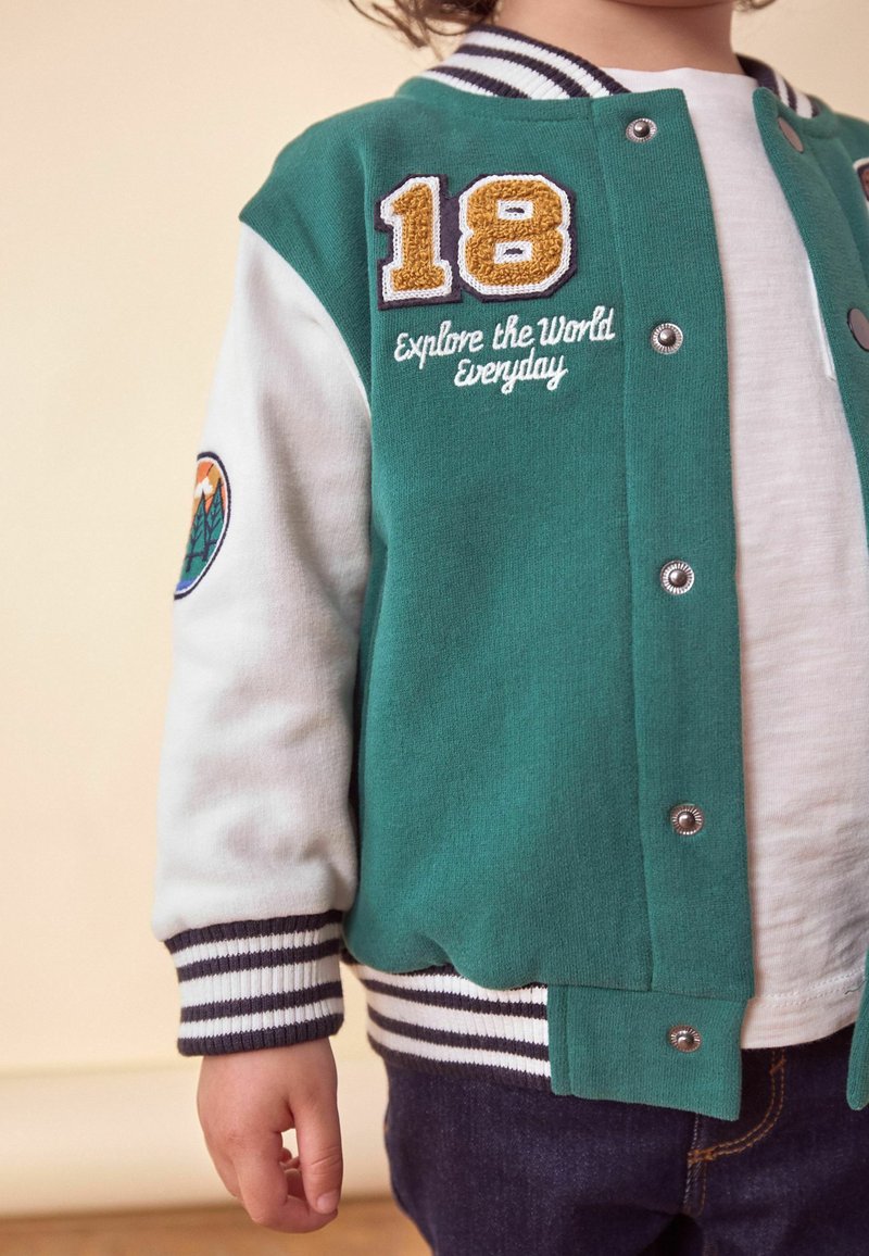 DESIGN - Giacca college oversize blu con stemmi