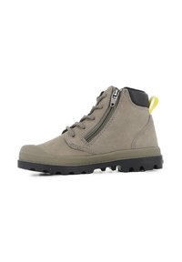 Cizme de drumeție din suede taupe cu talpă neagră, fermoar pe lateral, șireturi în față, guler căptușit negru pentru glezne și o bucată de prindere galbenă pe călcâi.