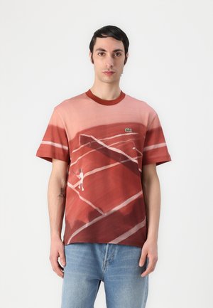 Tricou cu mâneci scurte, în degrade de roșu și roz, cu un print cu teren de tenis și un mic logo verde pe piept. Material moale, gât clasic.