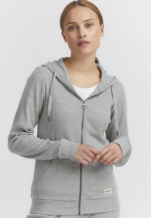 Gray zip-up hoodie with drawstring hood, ribbed cuffs, and hem. Made from a soft fabric, featuring a small brand label on the lower edge.