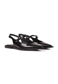Zapatos de piel negra tipo slingback con punta afilada, que presentan un diseño con cortes y una pequeña hebilla ajustable en la correa del tobillo.