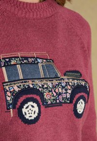 Kootud sviiter marjatoonis, millel on tikitud lillemustriga sõiduk. Kujundus sisaldab sõiduki siluetti koos detailse ratastega.