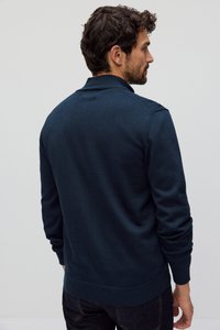 Granatowy sweter wykonany z miękkiej dzianiny, z prążkowanym kołnierzem i mankietami. Zaprojektowany w prostym kroju, bez widocznych wzorów.