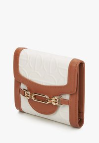 Kompaktní peněženka v bílé embosované látce s hnědými koženými akcenty. Obsahuje zlaté hardware a řetízkový detail na přední straně.