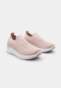Világos rózsaszín kötött slip-on cipők texturált dizájnnal, fehér talppal és húzófüllel a sarkán. Rugalmas anyag a kényelem érdekében.
