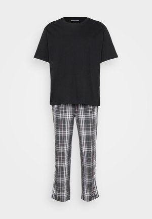 Fekete pamut, rövid ujjú póló, amely szürke kockás nadrággal van párosítva, fehér és zöld vonalakkal; a nadrág alja trapéz szabású.