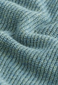 Strukturierter Strickstoff in verschiedenen Blau- und Grüntönen, mit einem gerippten Muster und weichen, flauschigen Fasern.
