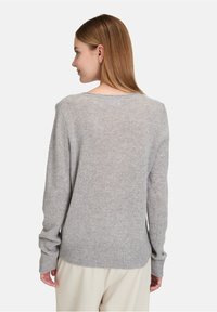 Šedý vlněný svetr s dlouhými rukávy, žebrovaným lemem a manžetami, a kulatým výstřihem. Měkká textura s uvolněným střihem.