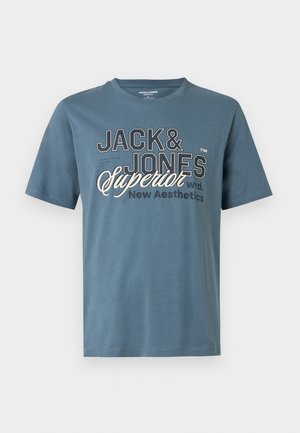 Tricou albastru de bumbac cu mâneci scurte, având inscripția albă îndrăzneață „JACK & JONES Superior New Aesthetics” în diferite fonturi și dimensiuni.