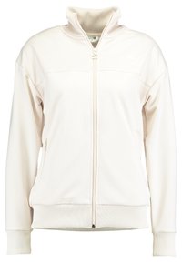 Giacca zip-up beige chiaro con colletto alto, polsini e orlo a coste, caratterizzata da un tessuto leggermente texturizzato e logo sul lato sinistro del petto.