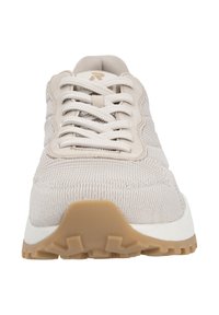 Baskets tricotées beige avec une tige texturée, bout rond et fermeture à lacets. La semelle est blanche avec un motif de grip en caoutchouc beige.