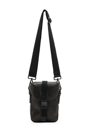 Zwarte leren crossbodytas met verstelbare brede riem en voorflap die wordt vastgemaakt met een verticale gespsluiting.