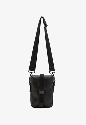 Sac bandoulière en cuir noir avec bandoulière large ajustable et rabat avant sécurisé par une sangle verticale à boucle.