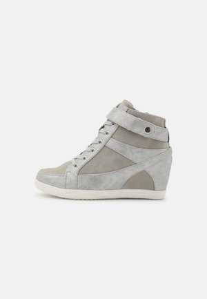 Baskets compensées en daim gris clair avec lacets à l’avant, bride de cheville à fermeture pression, et semelle en caoutchouc blanche sur un fond uni.