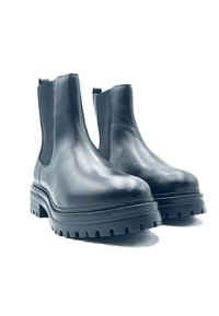 Bottines en cuir noir avec une semelle épaisse, des panneaux latéraux élastiques et une finition lisse, conçues pour la durabilité et le confort.